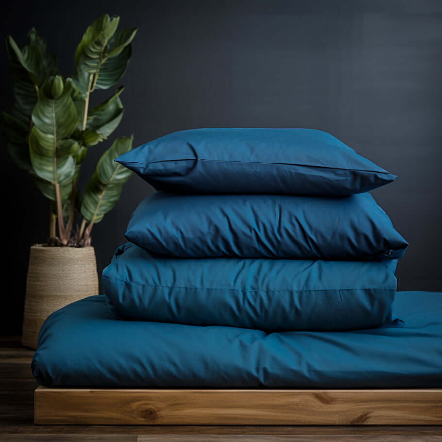 A stacked Navy Blue Cotton Bedding Set by Ebb and Weave on top of a wooden table.